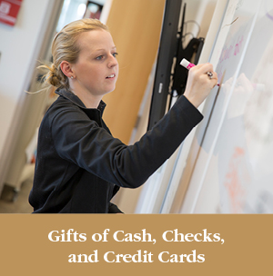 A girl writing on a whiteboard. Gifts of Cash, Check, and Credit Cards